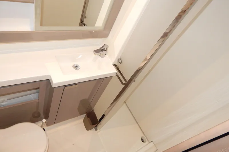  Yacht Photos Pics Modern bathroom interior on 2023 Fountaine Pajot Catamaran Elba 45, featuring sleek sink and cabinetry.