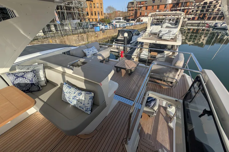  Yacht Photos Pics Luxurious 2025 Absolute 52 FLY yacht with elegant seating and modern design in a marina.