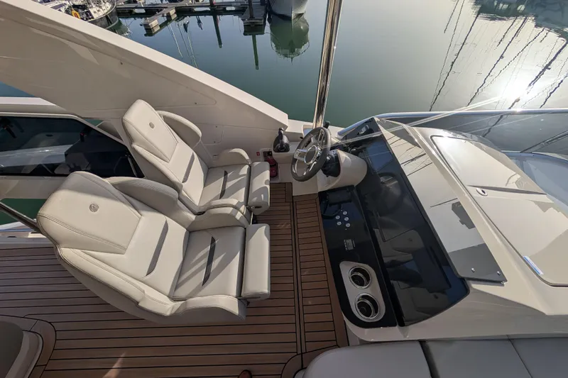  Yacht Photos Pics Flybridge helm of 2025 Absolute 52 FLY yacht with dual seats and modern controls.