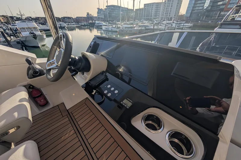  Yacht Photos Pics Helm of 2025 Absolute 52 FLY yacht with modern controls and marina view.