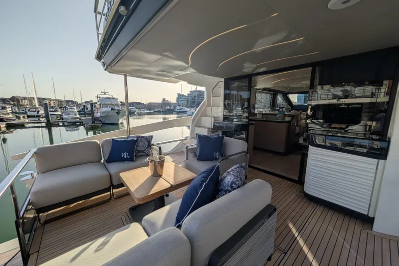  Yacht Photos Pics Luxurious 2025 Absolute 52 FLY yacht with elegant outdoor seating and marina view.