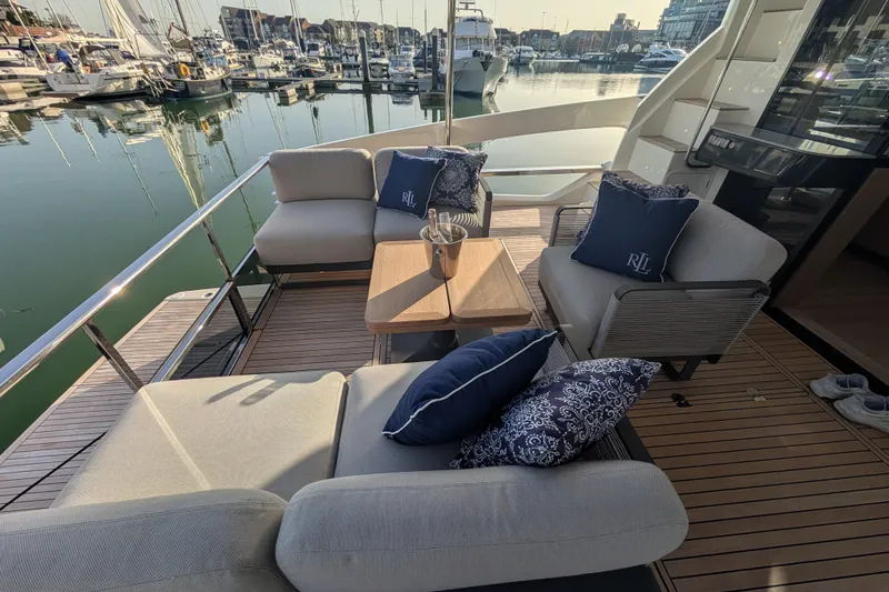  Yacht Photos Pics Luxurious seating area on 2025 Absolute 52 FLY yacht, docked in a marina.
