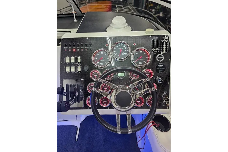  Yacht Photos Pics Dashboard of a 2004 Fountain 42 Lightning boat with gauges and steering wheel.