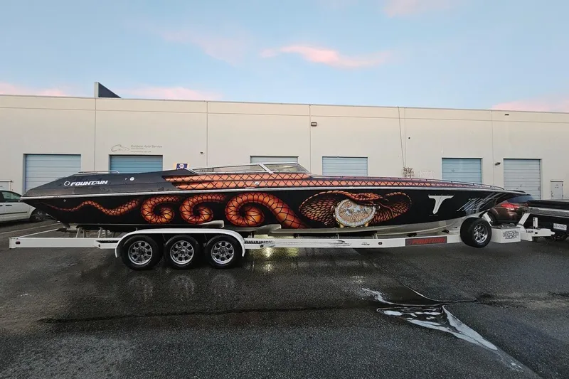  Yacht Photos Pics 2004 Fountain 42 Lightning speedboat with custom snake-themed design on a trailer.