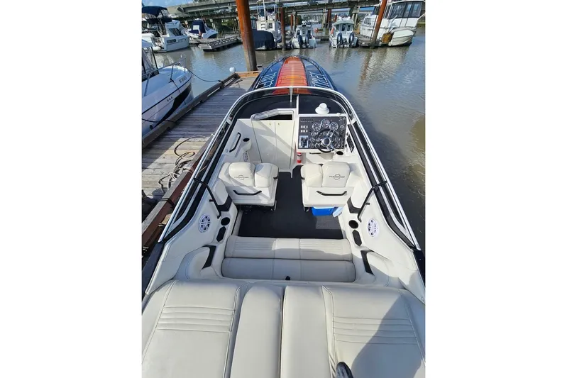  Yacht Photos Pics 2004 Fountain 42 Lightning boat interior with white seating and control panel at dock.