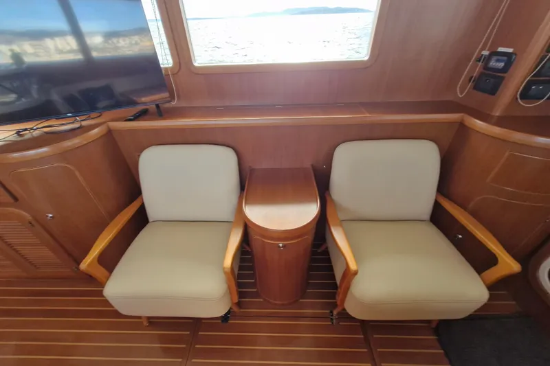 Mazu Yacht Photos Pics Interior of 2011 Adagio 58 yacht with two chairs and a small table.