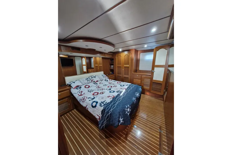 Mazu Yacht Photos Pics Luxurious Adagio 58 yacht bedroom interior, featuring wood paneling and nautical-themed bedding, 2011 model.