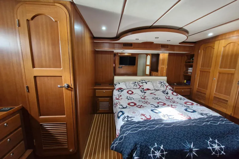Mazu Yacht Photos Pics Luxurious Adagio 58 yacht bedroom with nautical-themed bedding, wooden interior, and ambient lighting.