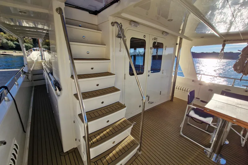 Mazu Yacht Photos Pics Luxurious 2011 Adagio 58 yacht interior with stairs, table, and scenic water view.