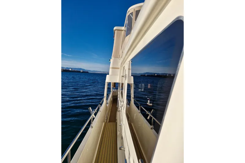 Mazu Yacht Photos Pics Side view of 2011 Adagio 58 yacht on calm blue waters under clear sky.