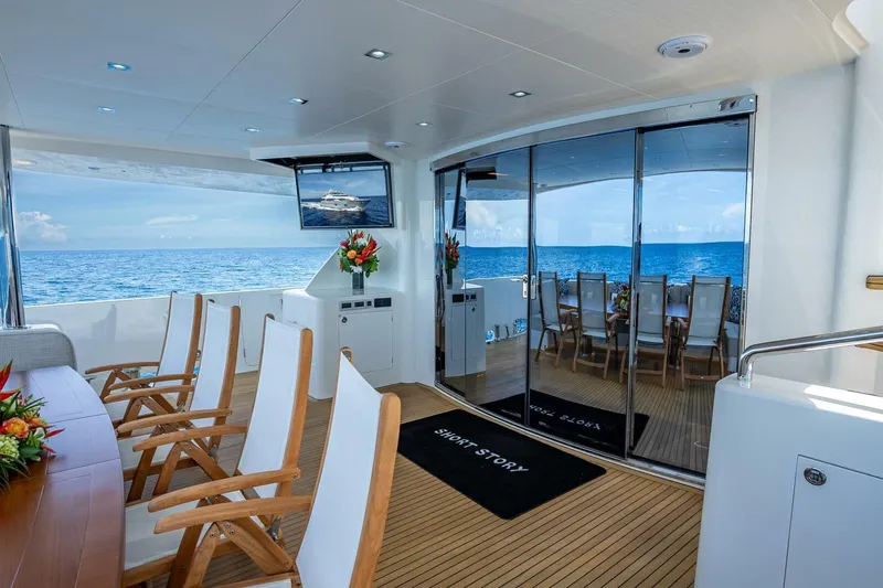 Short Story Yacht Photos Pics Luxurious Horizon RP120 yacht deck with ocean view, featuring elegant seating and dining area, 2017 model.