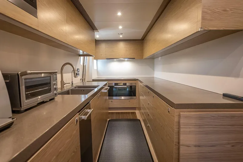 Short Story Yacht Photos Pics Modern galley kitchen on 2017 Horizon RP120 yacht with wood cabinetry and stainless steel appliances.