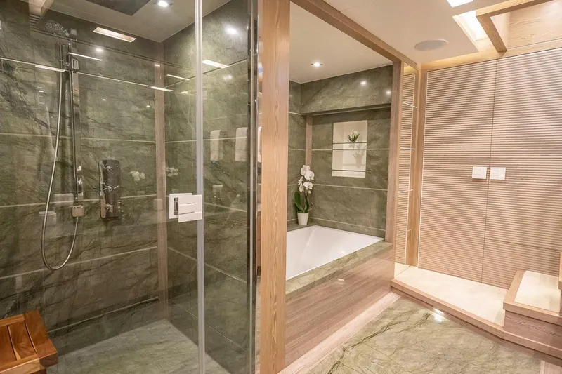 Short Story Yacht Photos Pics Luxurious bathroom with glass shower, marble walls, and elegant bathtub in Horizon RP120 yacht.