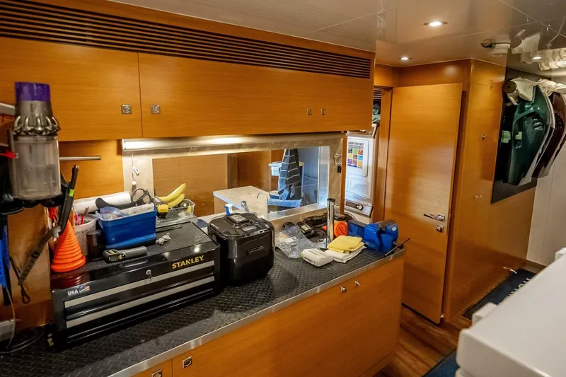 Short Story Yacht Photos Pics Laundry room in 2017 Horizon RP120 yacht with wooden cabinets and various tools.