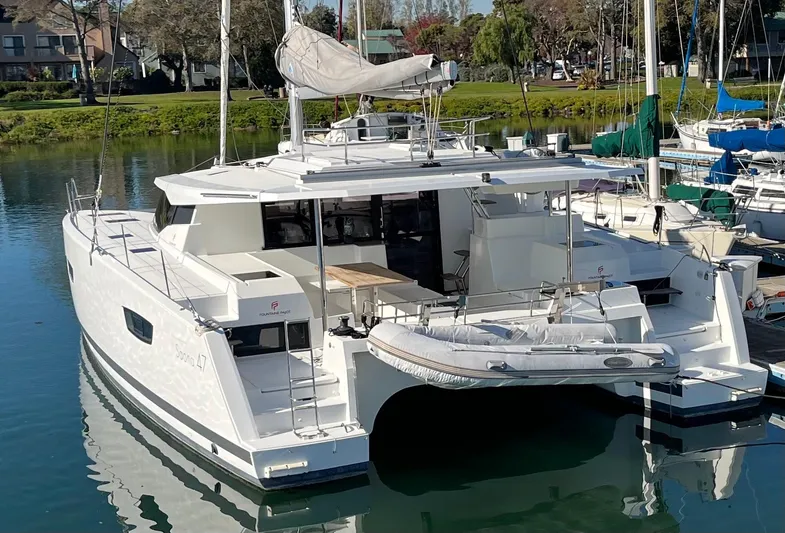 Bright Side Yacht Photos Pics 2019 Fountaine Pajot Saona 47 catamaran docked in a serene marina setting.