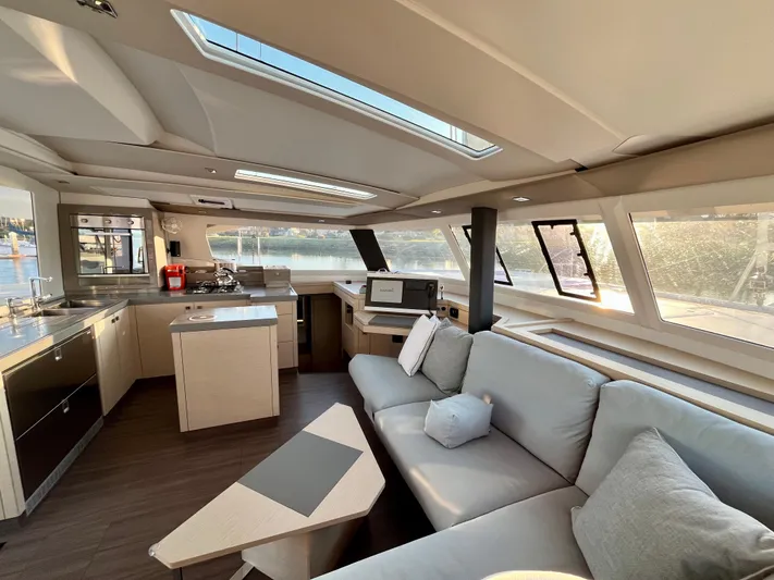 Bright Side Yacht Photos Pics Luxurious interior of 2019 Fountaine Pajot Saona 47 catamaran with modern kitchen and seating area.