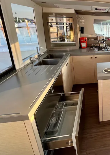 Bright Side Yacht Photos Pics Modern kitchen interior of 2019 Fountaine Pajot Saona 47 catamaran with open drawers and appliances.