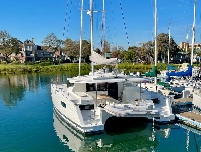 Bright Side Yacht Photos Pics 2019 Fountaine Pajot Saona 47 catamaran docked in a serene marina setting.