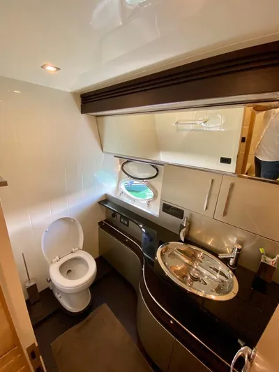  Yacht Photos Pics Luxurious bathroom in a 2008 Uniesse 68 yacht with modern fixtures and porthole.