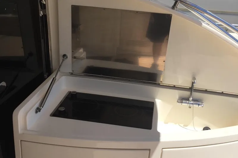  Yacht Photos Pics Outdoor kitchen area on a 2008 Uniesse 68 yacht, featuring a sink and stovetop.