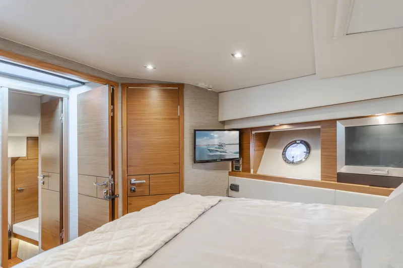 Chapter Three Yacht Photos Pics Luxurious interior of 2018 Tiara F44 yacht bedroom with modern design and porthole window.