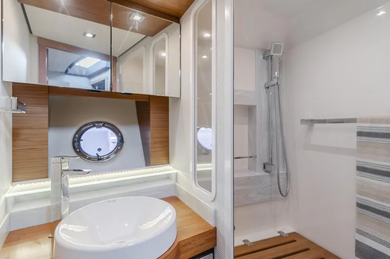 Chapter Three Yacht Photos Pics Luxurious bathroom interior of 2018 Tiara F44 yacht with modern fixtures and porthole window.