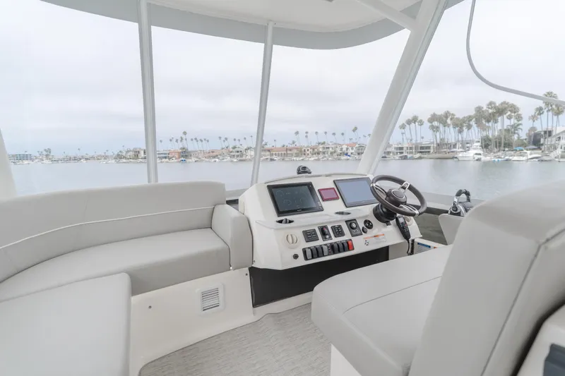 Chapter Three Yacht Photos Pics Interior view of 2018 Tiara F44 yacht helm with modern controls and waterfront backdrop.