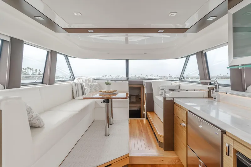 Chapter Three Yacht Photos Pics Luxurious interior of a 2018 Tiara F44 yacht with modern seating and kitchen area.