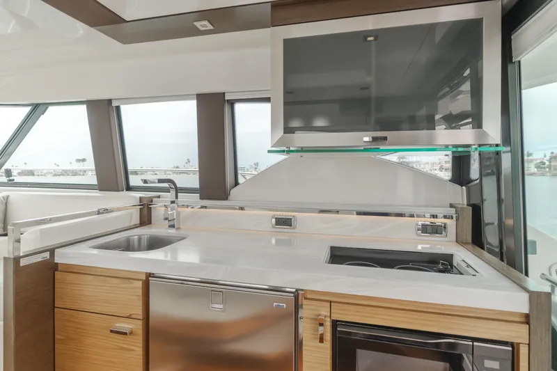 Chapter Three Yacht Photos Pics Modern kitchen interior of 2018 Tiara F44 yacht with sleek appliances and panoramic windows.