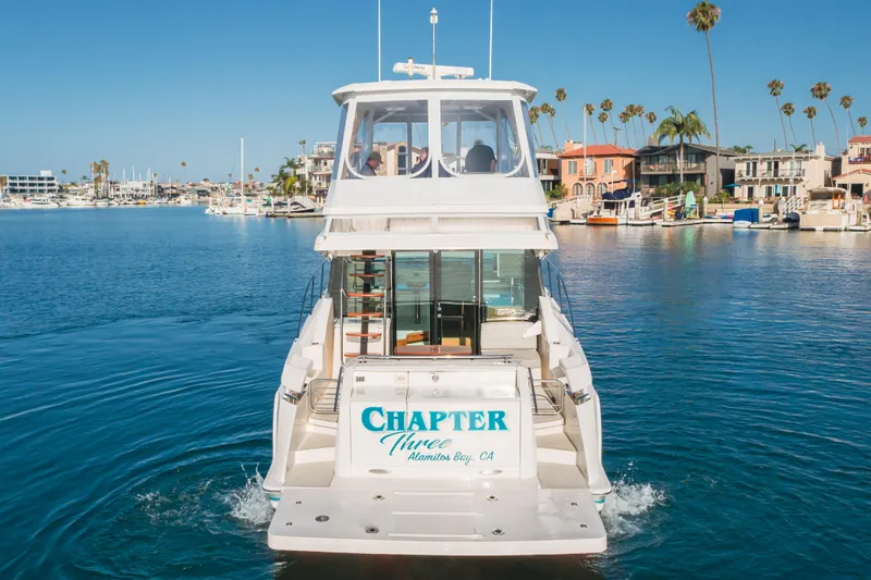 Chapter Three Yacht Photos Pics 2018 Tiara F44 yacht cruising in a scenic marina with waterfront homes.