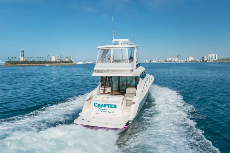 Chapter Three Yacht Photos Pics 2018 Tiara F44 yacht cruising in a scenic coastal city backdrop.