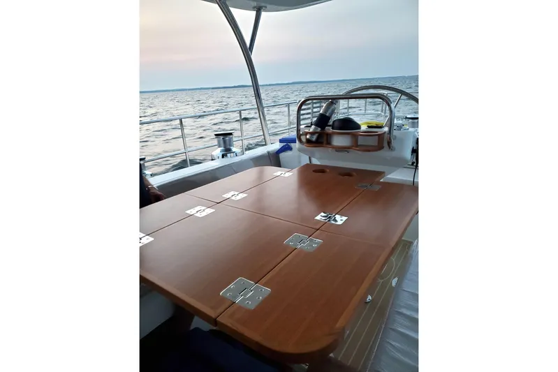 Centurion Yacht Photos Pics Luxurious 2023 Bluewater 56 yacht deck with wooden table, ocean view.