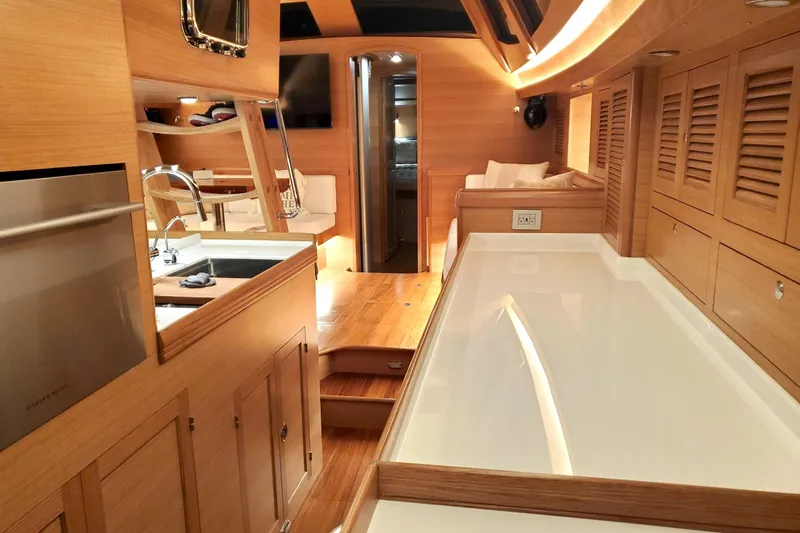 Centurion Yacht Photos Pics Luxurious interior of 2023 Bluewater 56 yacht, featuring modern kitchen and elegant wood finishes.