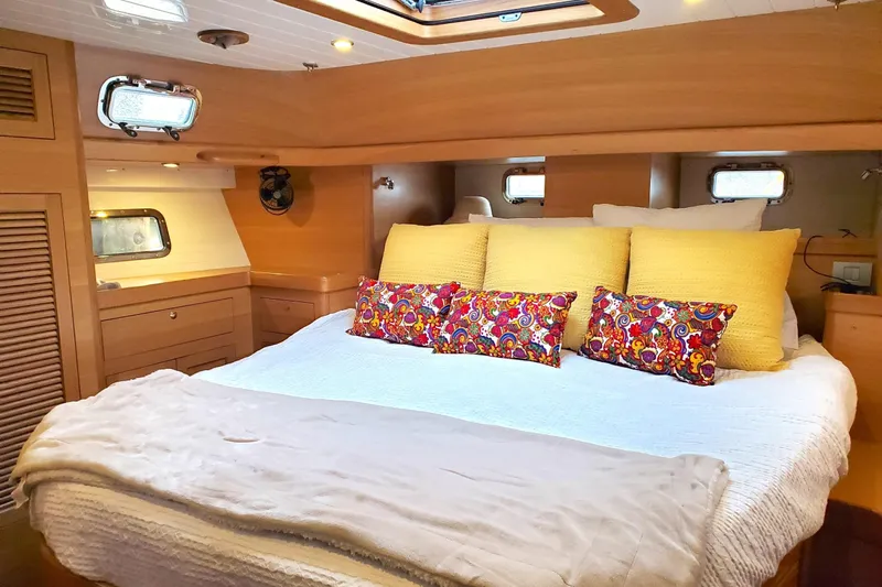Centurion Yacht Photos Pics Luxurious 2023 Bluewater 56 yacht cabin with colorful pillows and elegant wood finish.
