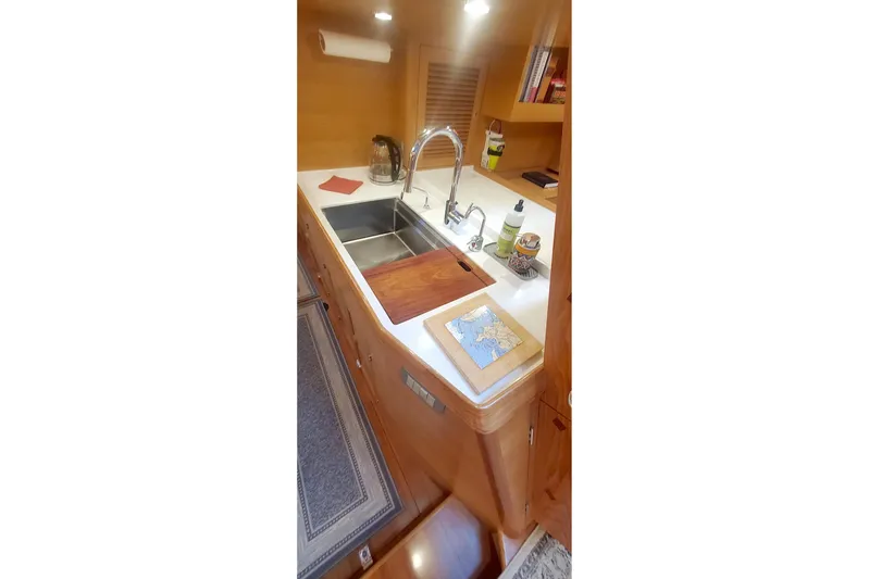 Centurion Yacht Photos Pics Modern kitchen area in 2023 Bluewater 56 yacht with wooden cabinetry and stainless steel sink.