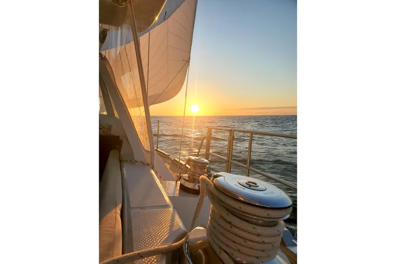 Centurion Yacht Photos Pics 2023 Bluewater 56 yacht sailing at sunset on open sea.