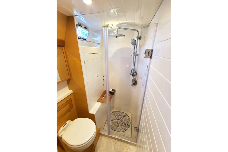 Centurion Yacht Photos Pics Luxurious bathroom in 2023 Bluewater 56 yacht with modern shower and wooden cabinetry.
