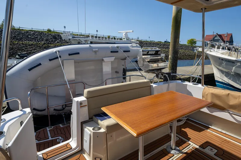 Yacht Photos Pics 2023 Ranger Tugs R-31 S boat deck with seating and table, docked at marina.