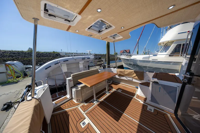  Yacht Photos Pics 2023 Ranger Tugs R-31 S boat deck with seating and table, docked at marina.
