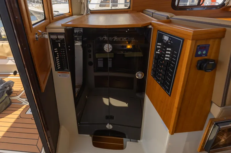  Yacht Photos Pics 2023 Ranger Tugs R-31 S interior with control panels and wooden cabinetry.