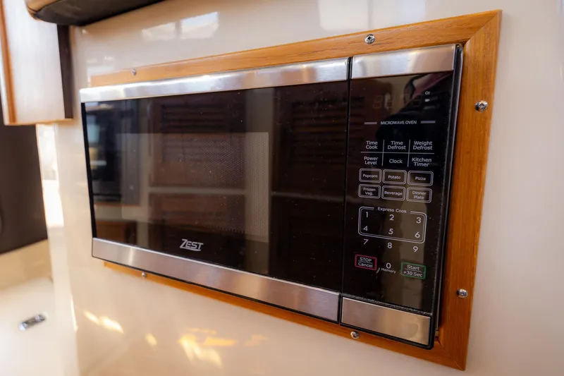 Yacht Photos Pics Microwave in 2023 Ranger Tugs R-31 S boat kitchen, featuring wood trim and digital controls.