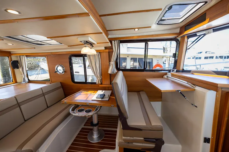  Yacht Photos Pics 2023 Ranger Tugs R-31 S interior with elegant seating and wooden accents.