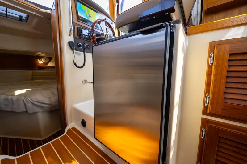  Yacht Photos Pics 2023 Ranger Tugs R-31 S interior with stainless steel fridge and cozy cabin.