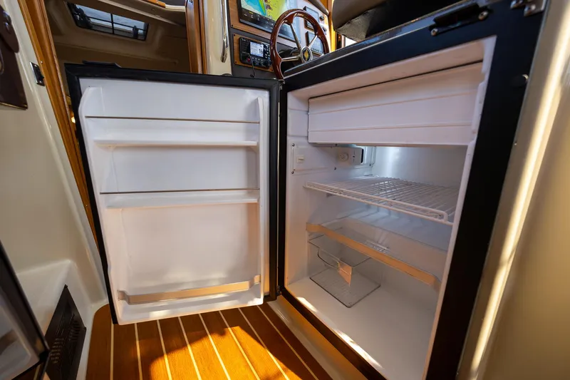  Yacht Photos Pics 2023 Ranger Tugs R-31 S boat interior with open refrigerator, showcasing storage space.