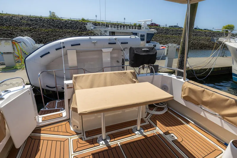  Yacht Photos Pics 2023 Ranger Tugs R-31 S boat deck with seating and table, docked at marina.