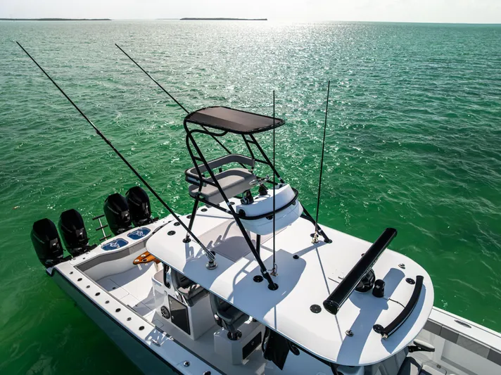  Yacht Photos Pics 2024 Freeman 42 LR boat on serene green ocean waters, equipped with multiple fishing rods.