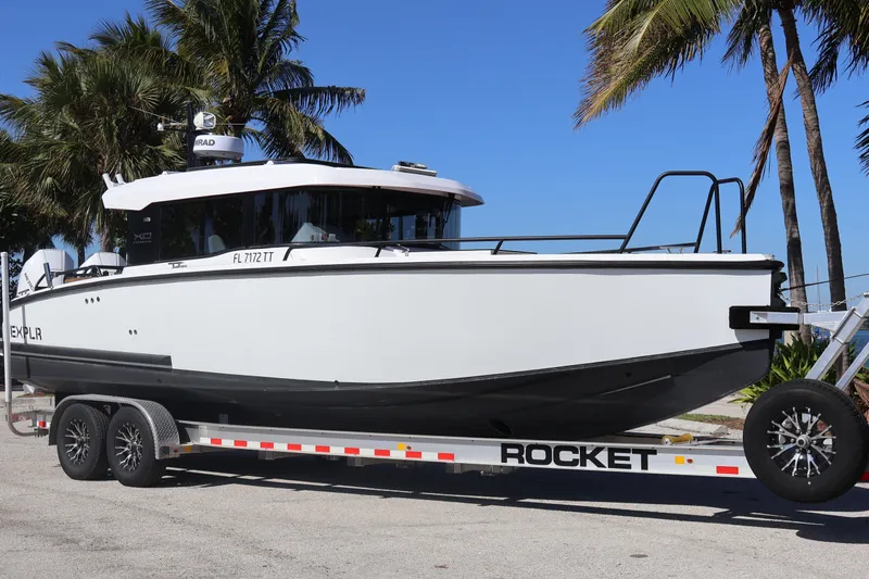  Yacht Photos Pics 2024 XO Boats EXPLR 10 S Plus on trailer, parked near palm trees under clear blue sky.
