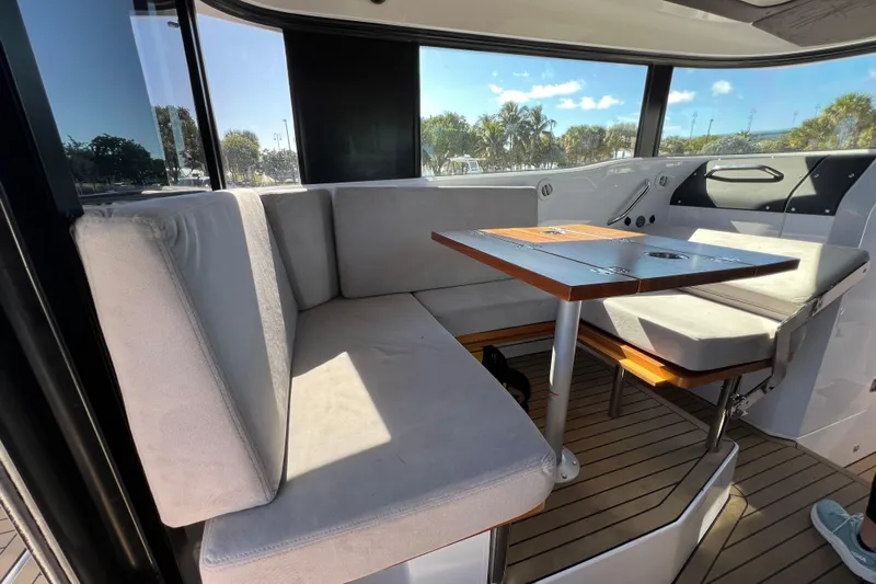  Yacht Photos Pics 2024 XO Boats EXPLR 10 S Plus interior with cushioned seating and wooden table.