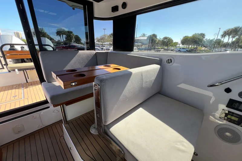  Yacht Photos Pics Interior of 2024 XO Boats EXPLR 10 S Plus with cushioned seating and wooden table.