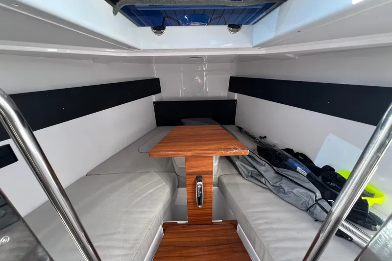  Yacht Photos Pics 2024 XO Boats EXPLR 10 S Plus cabin interior with wooden table and seating.